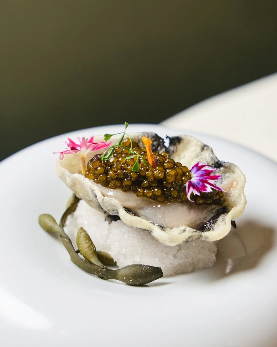 Cru, redefined. Fresh Island Creek oyster with star flower, cr&egrave;me fra&icirc;che, and Kaluga caviar, served in an edible oyster shell.

📸  @briansamuelsphotography