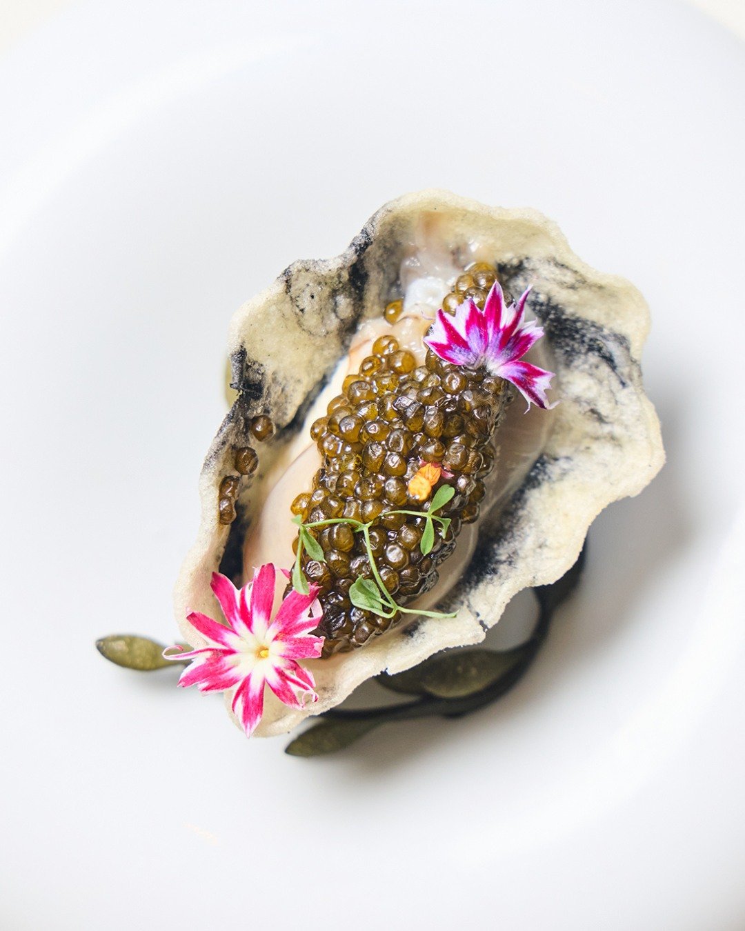 The first course of Chef Robert&rsquo;s tasting menu: Oyster &amp; Caviar&mdash;crispy oyster shell topped with Kaluga caviar, cr&egrave;me fra&icirc;che, and star flower.

📸 @briansamuelsphotography