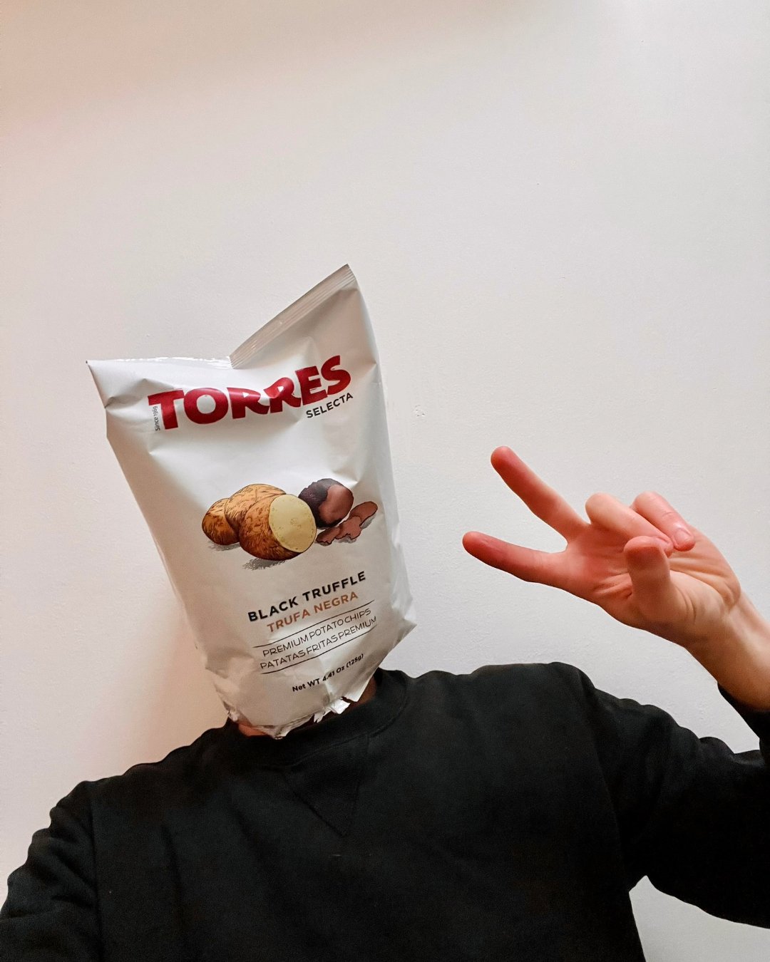 Real Housewives of Clapton, anonymous comedy meme creator's headshot with a bag of Torres black truffle potato chips on his head, making a peace sign with his hand.