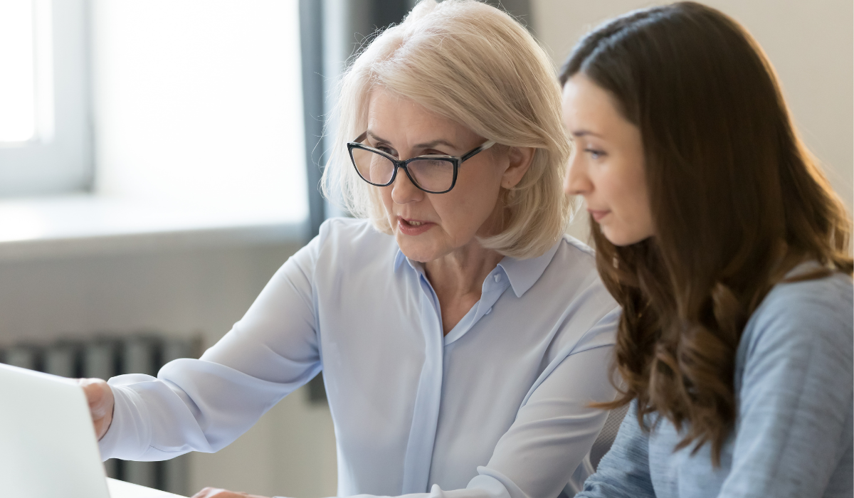 Manager reviewing work closely with a team member in a supportive micro-mentoring style rather than a controlling micromanagement approach