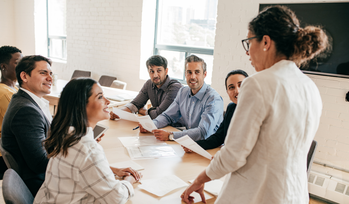 New team leader confidently addressing their team as a unified group during a structured weekly meeting