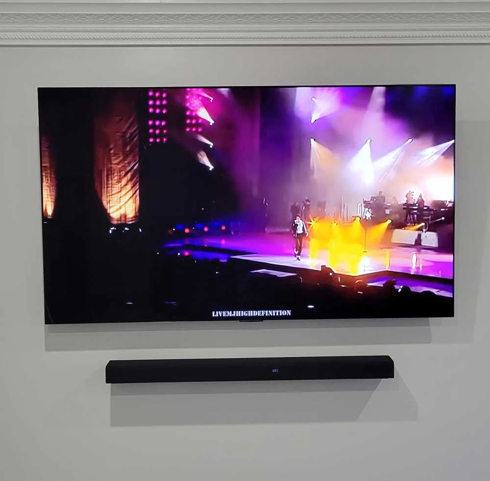 Television screen displaying a live concert performance with colorful stage lighting and a singer on stage.