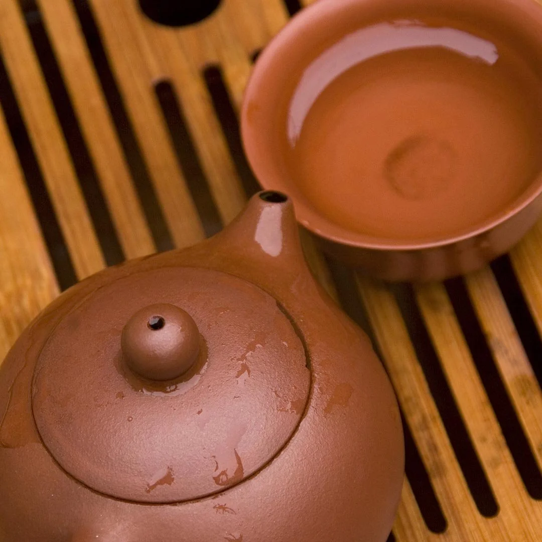 Clay teapot and cup on wood table