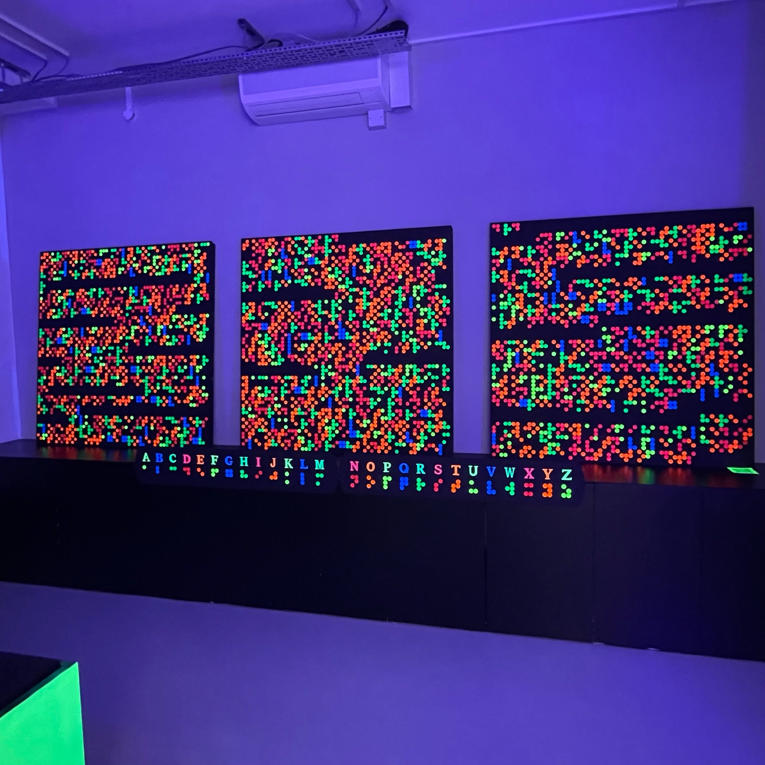 Braille panels lit under UV light