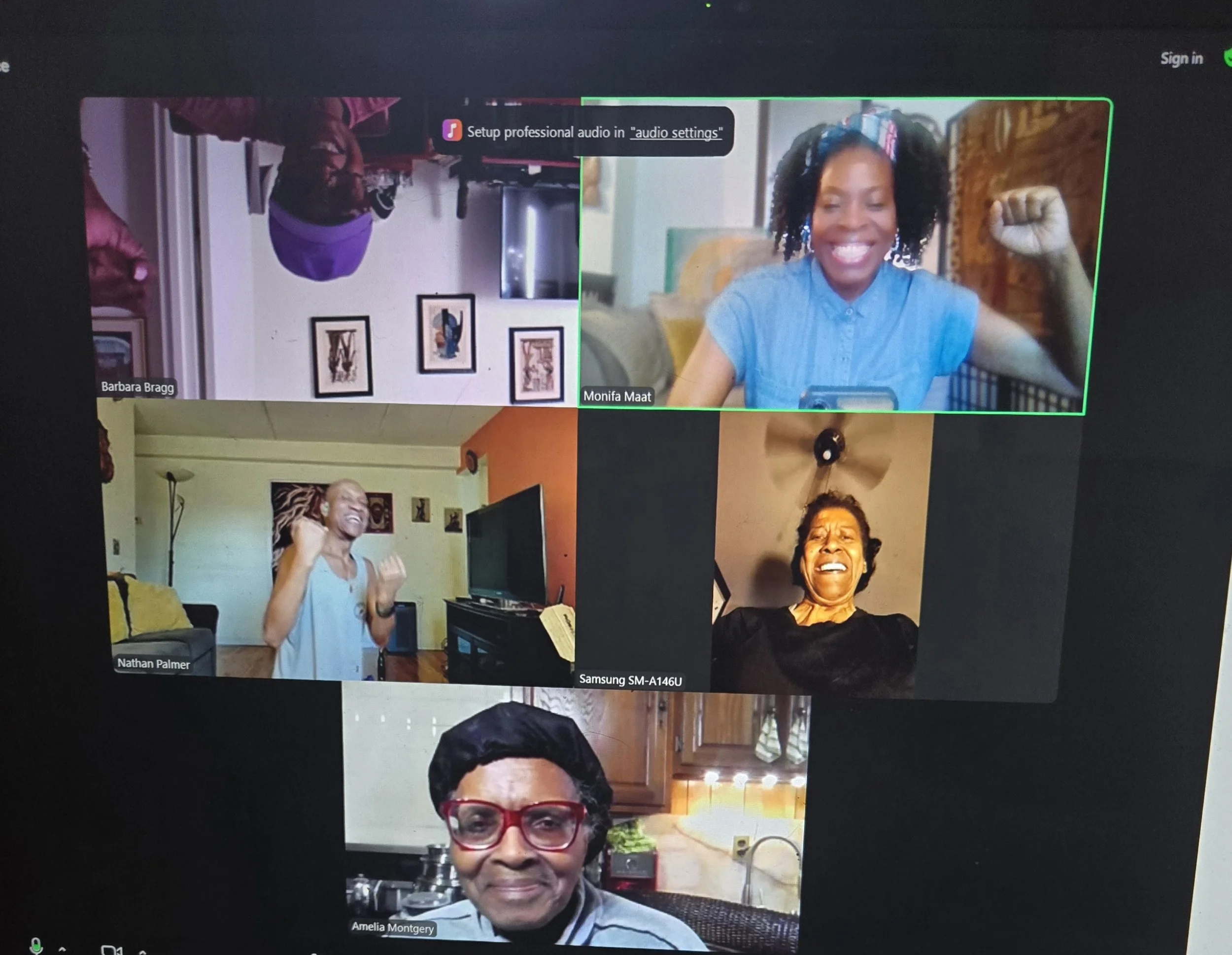 Screenshot of a video call with five women, each in their own home. The women are smiling, laughing, and celebrating, with some showing their fists in a gesture of empowerment.