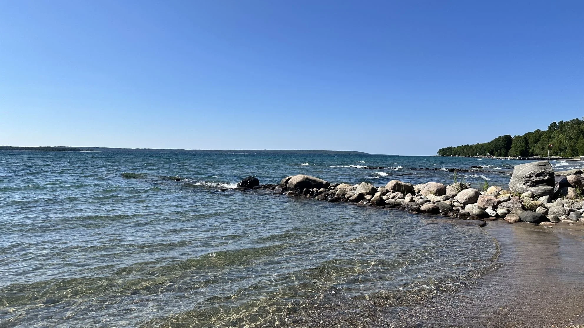 Clear shallow water over stone and sand along the Georgian Bay shore in Tiny Township, Simcoe County, Ontario.