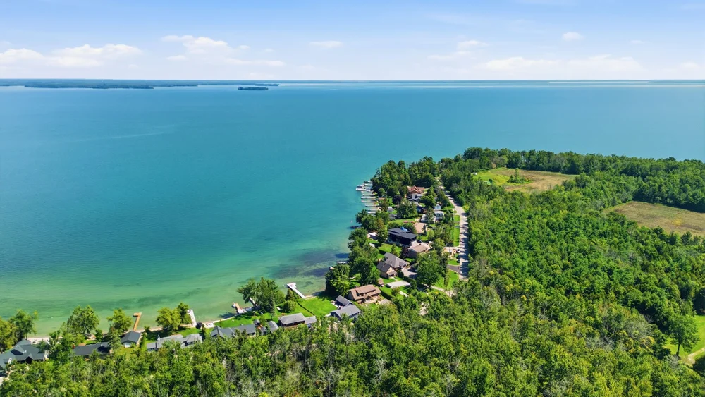 Aerial view of Lake Simcoe and the Oro-Medonte shoreline, with waterfront homes along a wooded shore