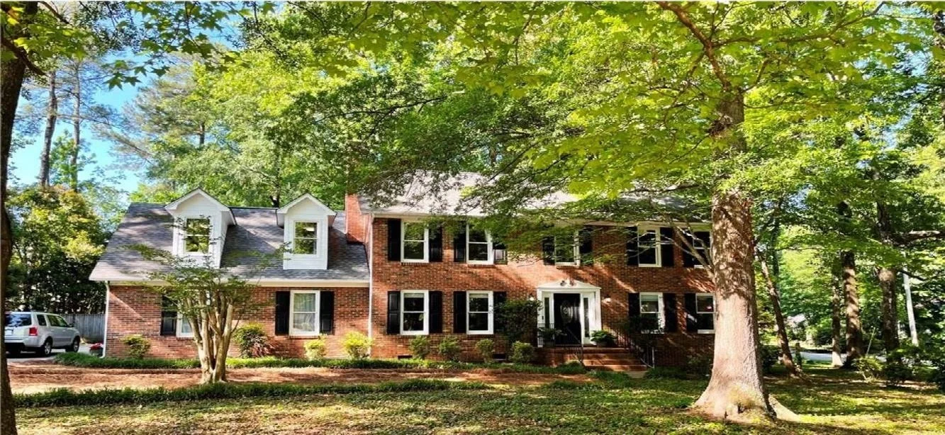A large home surrounded by trees on a moderately sized lot