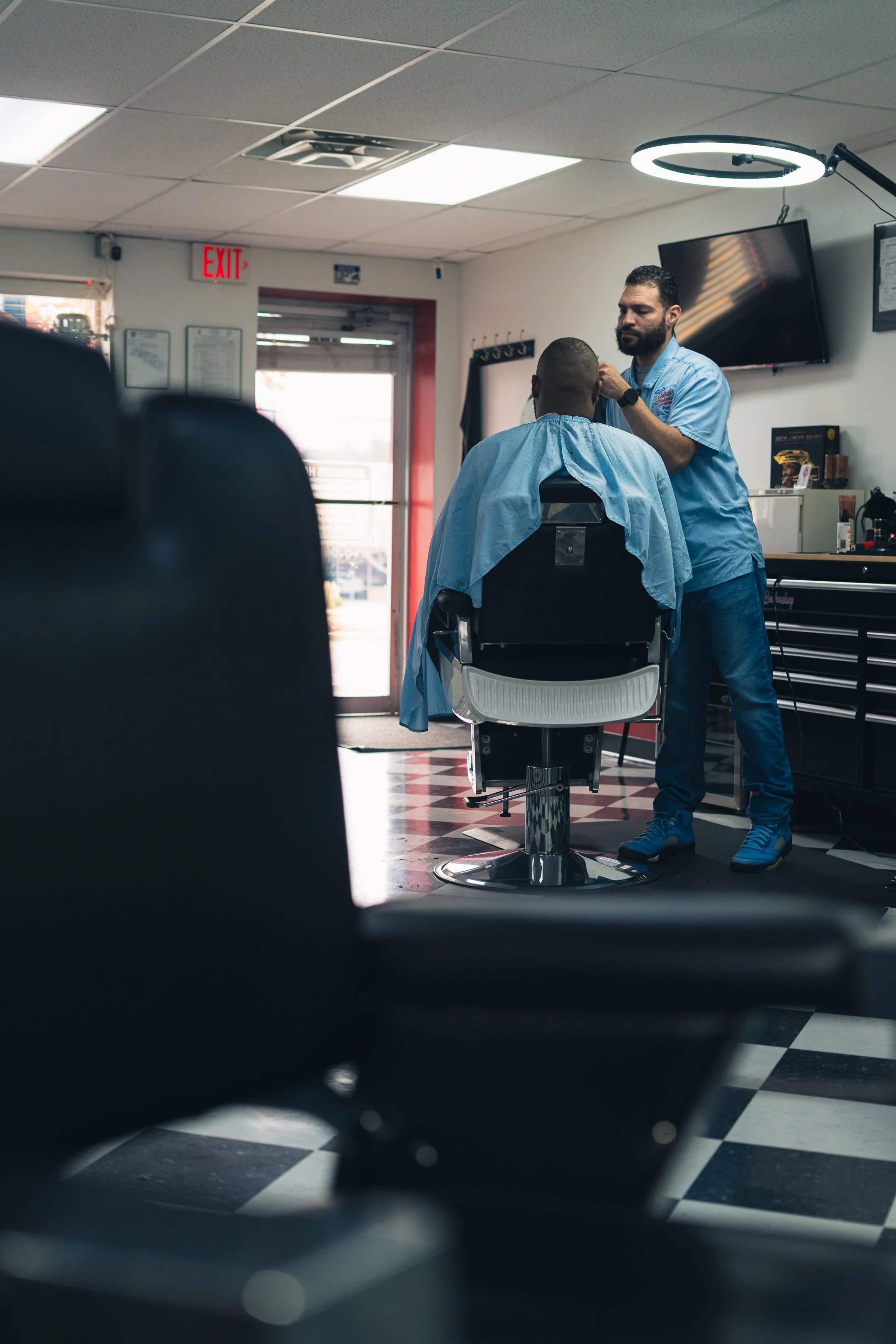 Barber giving a haircut to a customer in a barbershop.