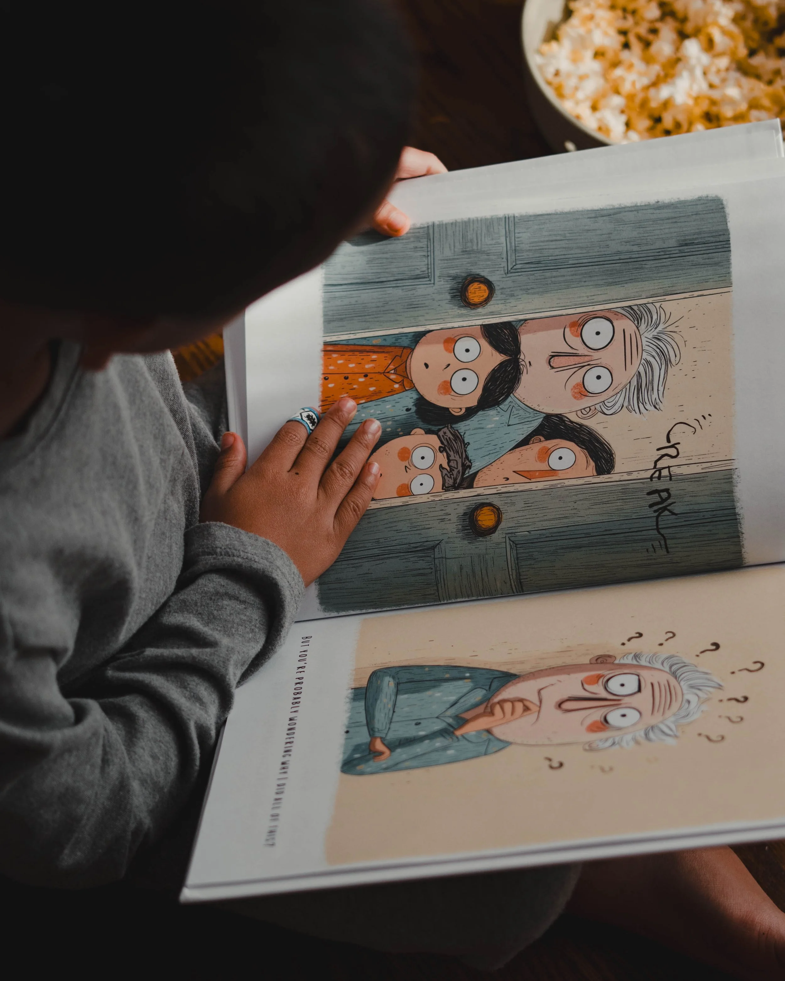 Child reading a colorful picture book with illustrations of surprised-looking characters, including an elderly person, in a cozy indoor setting, the book is titled "Everyone Thinks I'm Stinky" by Vinnie Venneri & Markus Palu, sold at Barnes and Noble