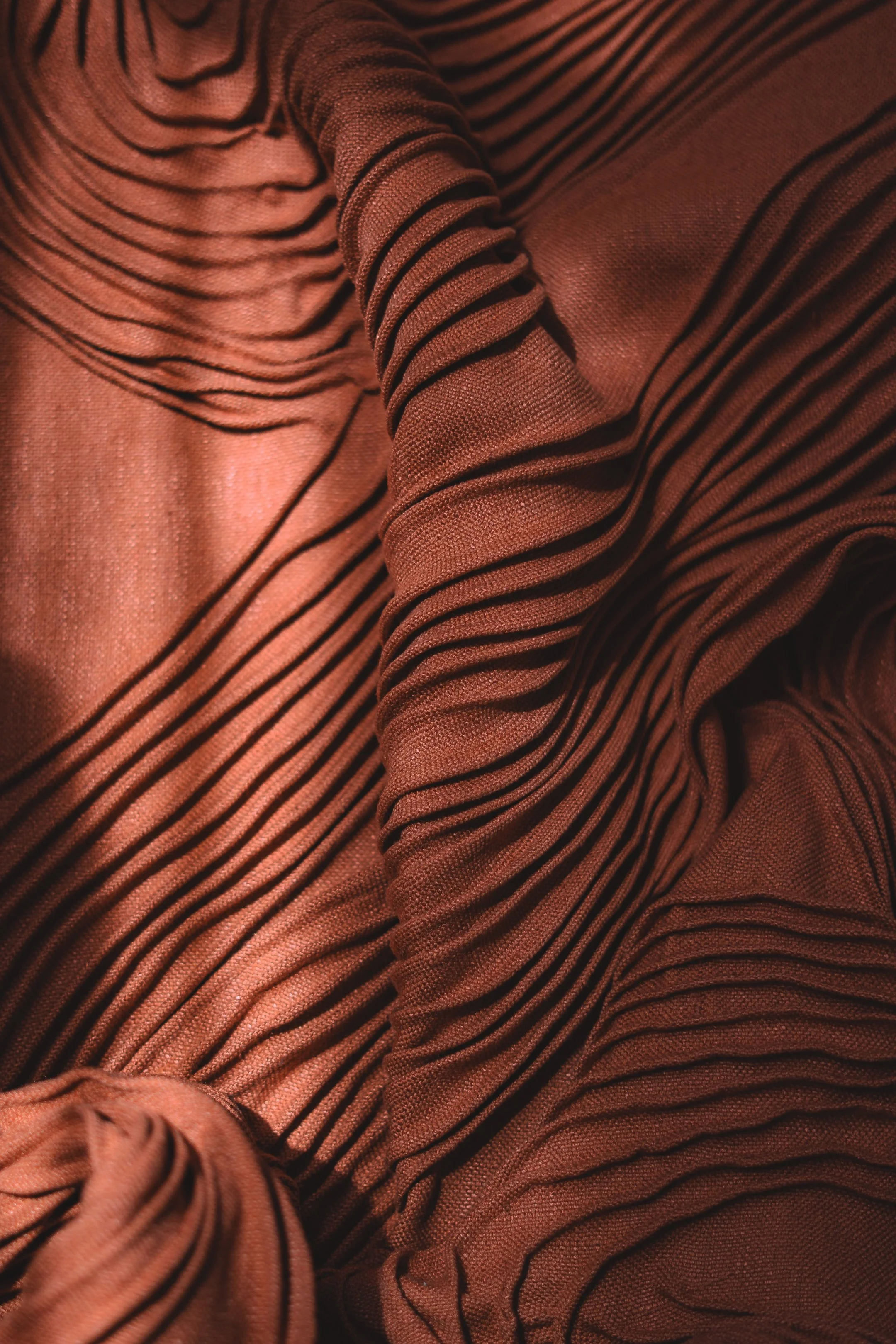 Close-up of red fabric with black stripes, with ruffles and folds.
