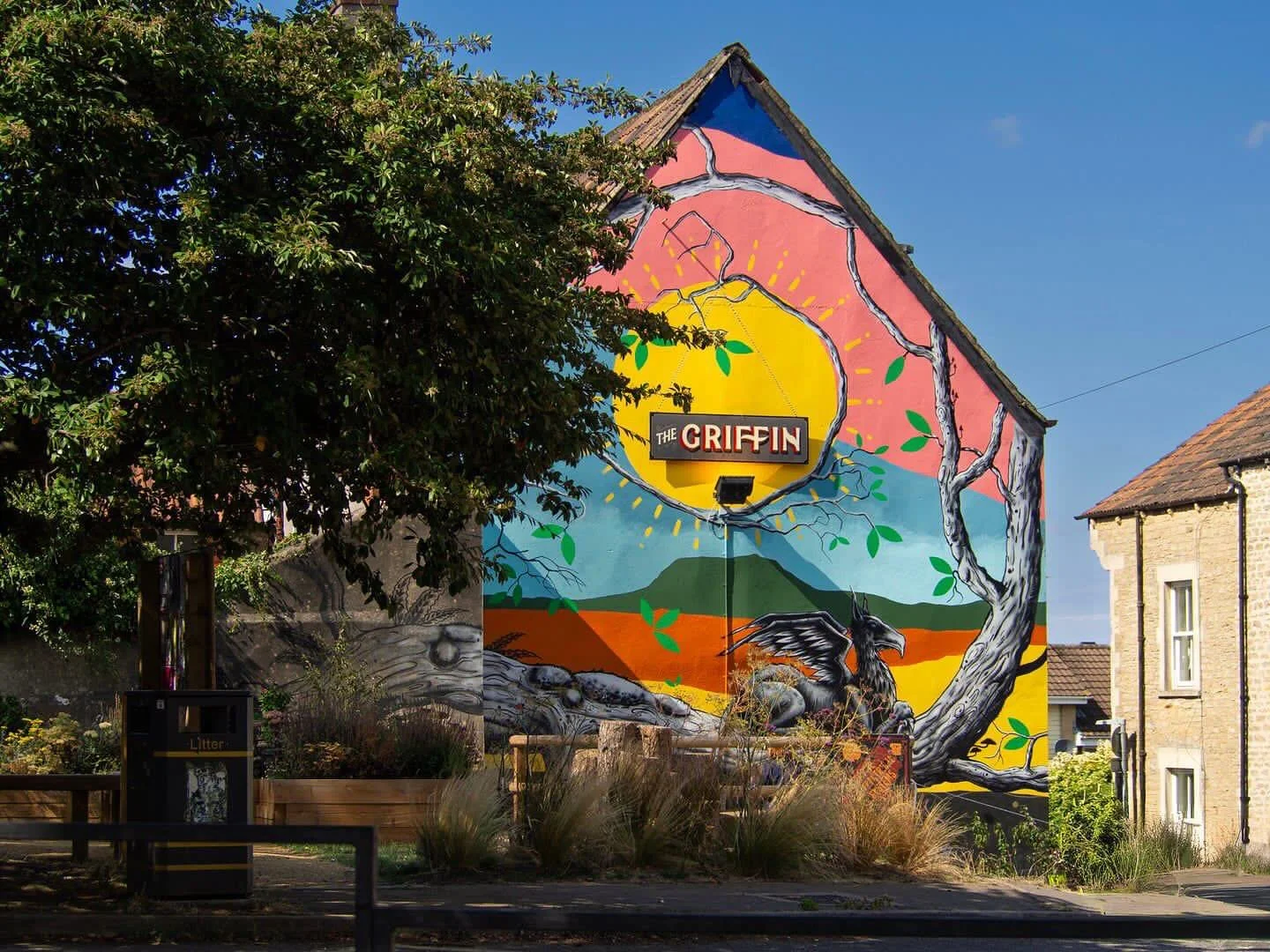 Cheerful blocks of colour and rays of sunshine from me @jennadoodles ☀️ mashed together with a gnarly mutant monochrome spray painted tree 🖤 from Paul Boswell @mutartist . The Trinity Tree mural emerges from the new lovely Trinity community garden, 