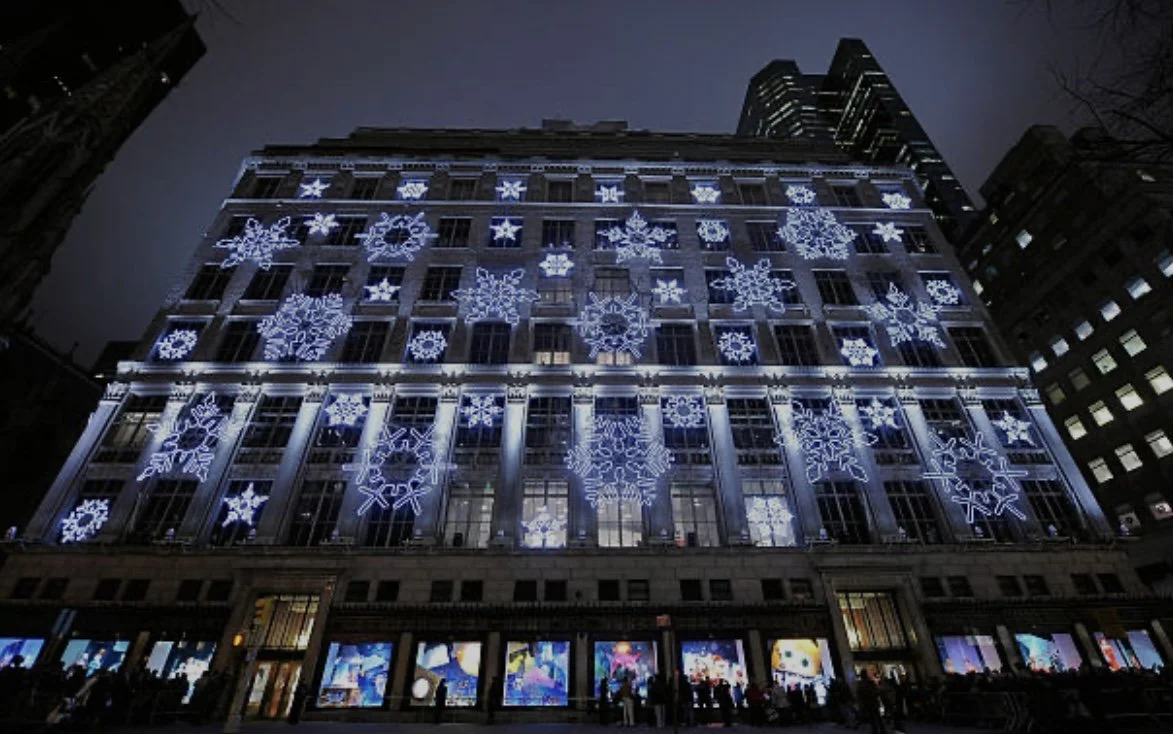 Building facade lit with large snowflake light installations for the holidays