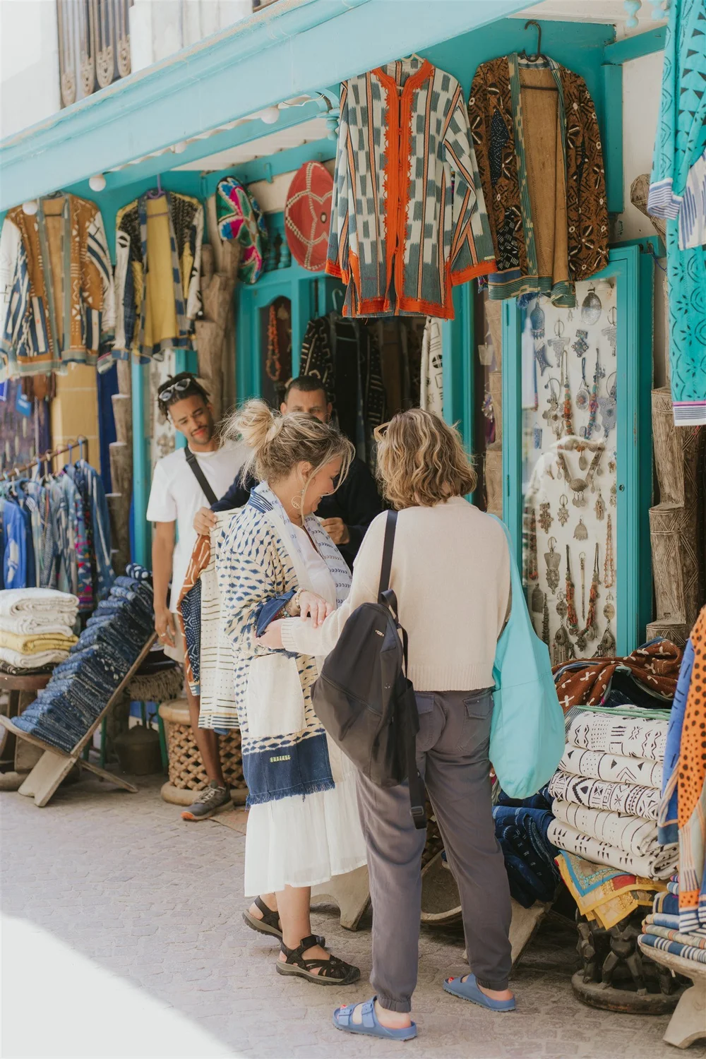 Retreat guests browsing a colorful market stall in the Fez medina on a Morocco yoga retreat