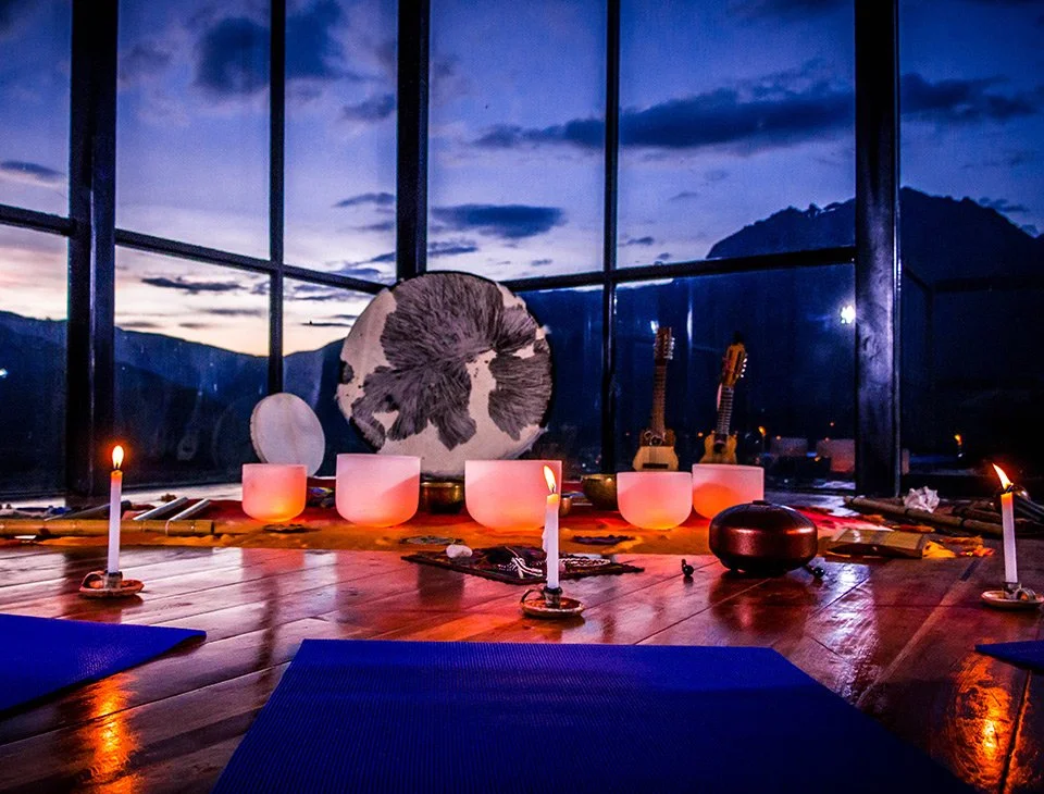 Crystal singing bowls set for a sound bath at dusk at a Peru yoga retreat