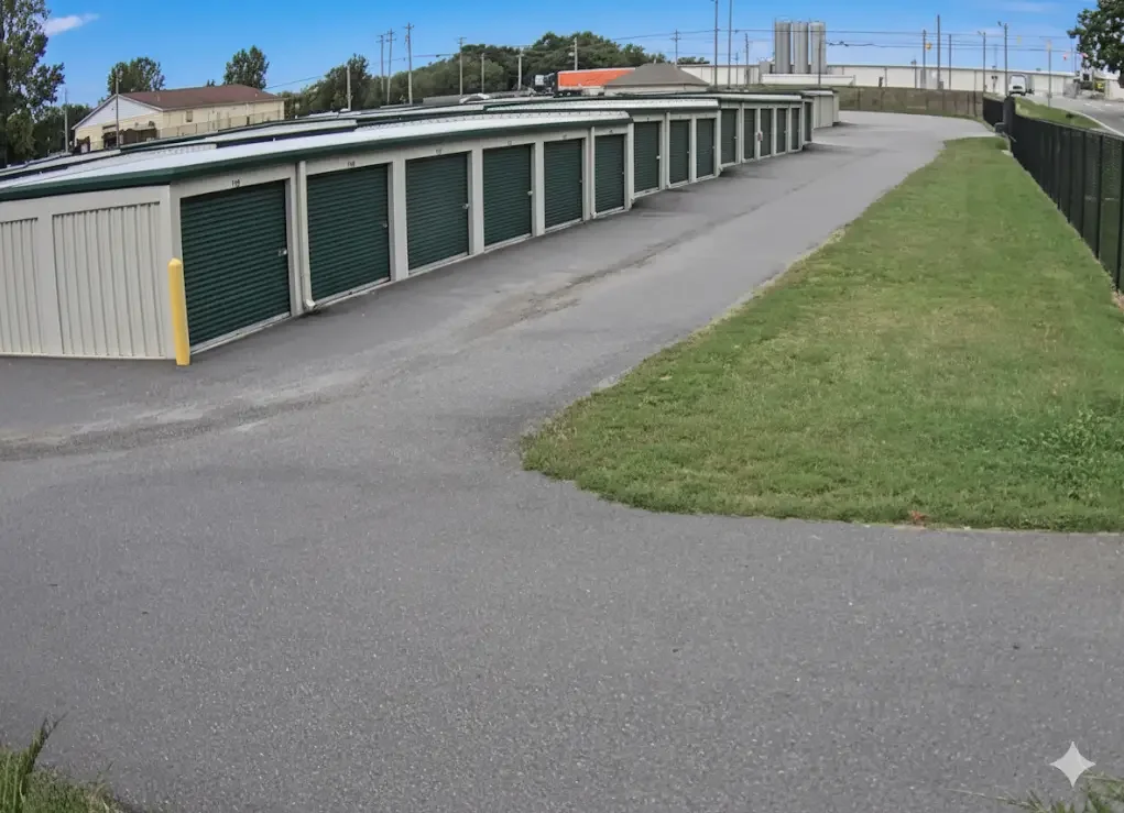 Row of clean green drive-up storage units with paved access lanes.