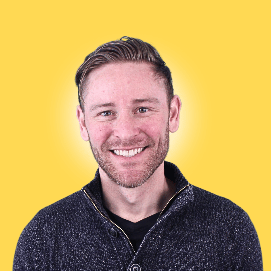Smiling person in green shirt against gray background
