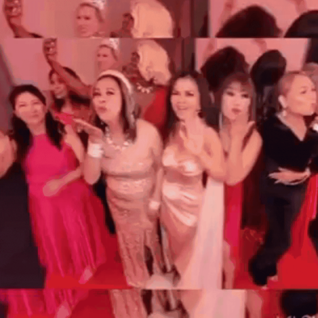 Several women stand together on a red carpet, featuring one in a stunning dress at the forefront.