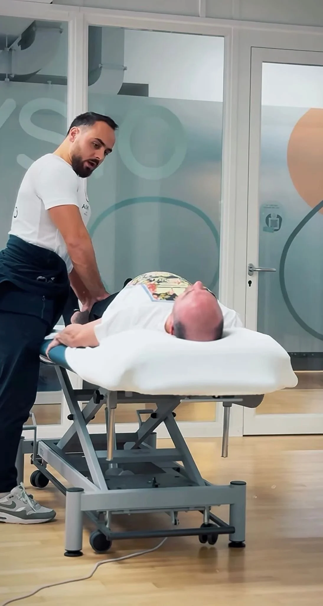 Ein Arzt oder Rettungssanitäter bereitet einen Patienten auf eine Untersuchung oder Behandlung vor, der auf einer beweglichen Liege liegt.