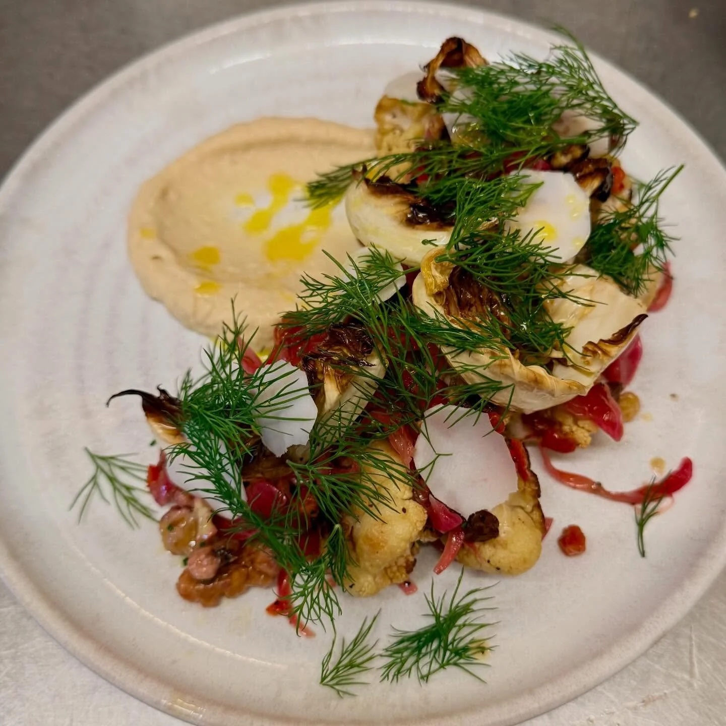 Check out our new vegan roast cauli salad!

The cauliflower and its leaves are roasted in English rapeseed oil, with butter bean hummus, lemon pickled red onions, raisins, walnuts and chili, a shed load of dill and cauliflower stem. Utterly delicious