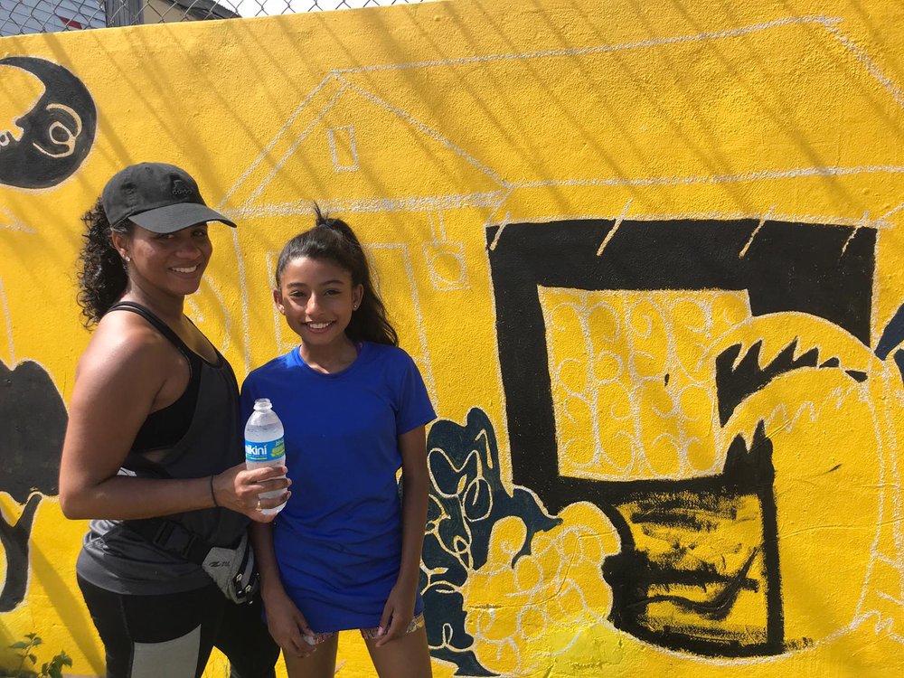  AD&amp;V team member and family posing for picture in front of mural 