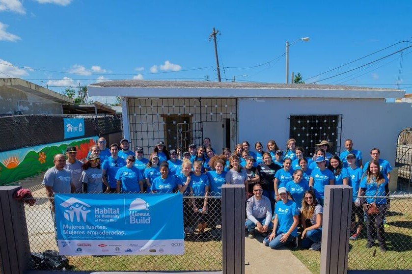  Volunteers posing for picture outside of home after reconstruction 