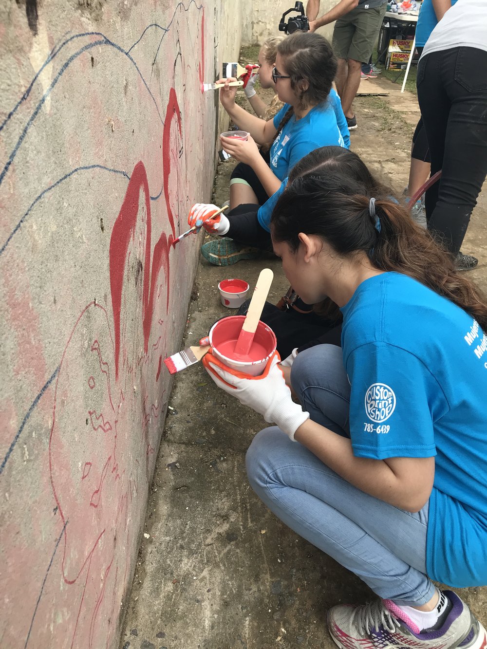  Volunteers working on mural outside of home 