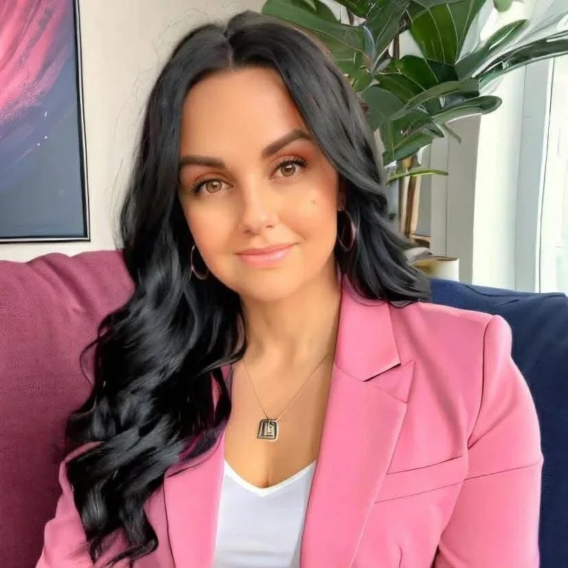 Picture of Brittany Gowler, a light skinned person with long dark hair wearing a pink jacket, hoop earrings, and a necklace.