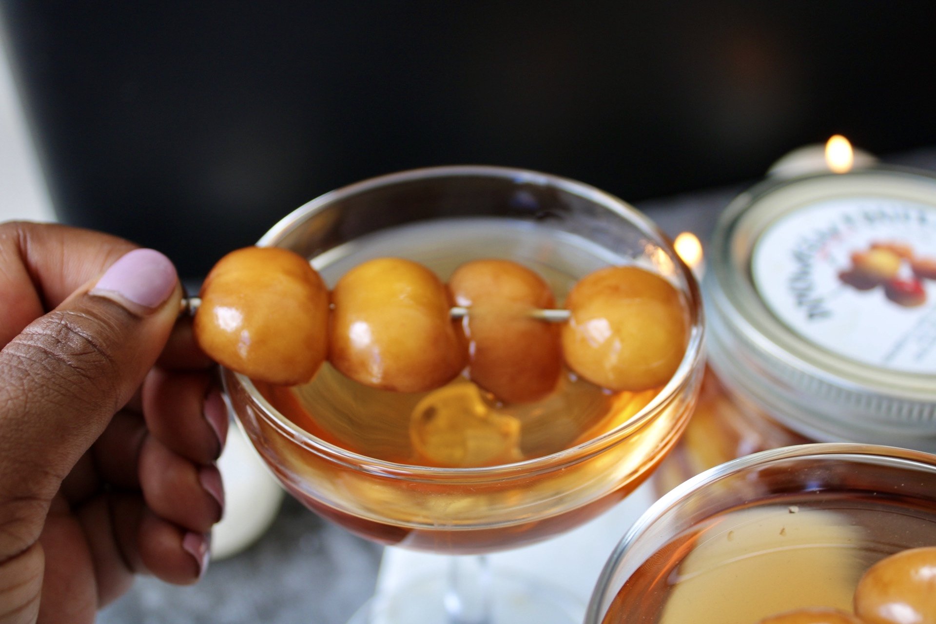 holding cocktail garnish of Drunken Fruit Cherry Vanilla