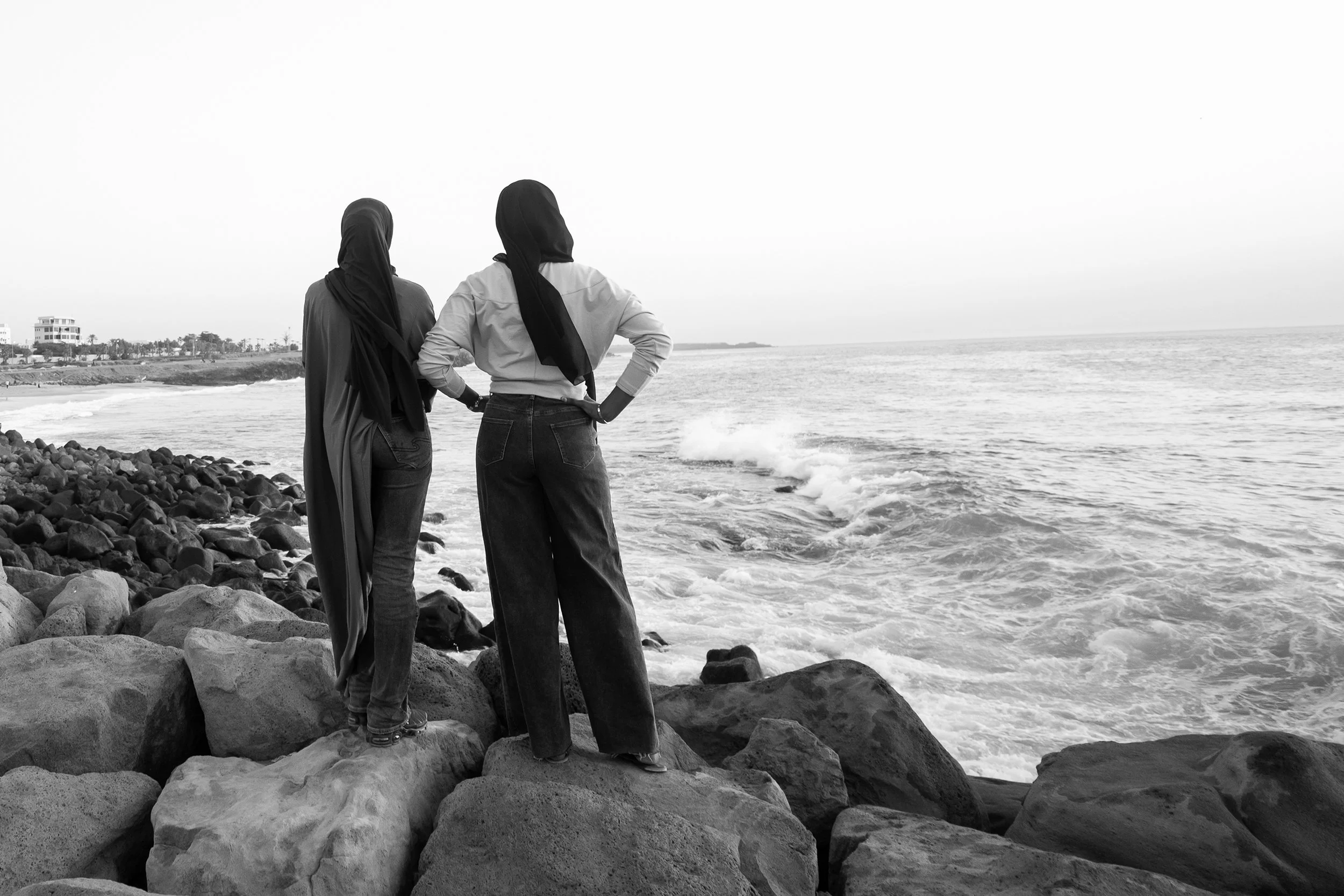 Young, Muslim women enjoying the coastline of Dakar, Senegal at dusk.