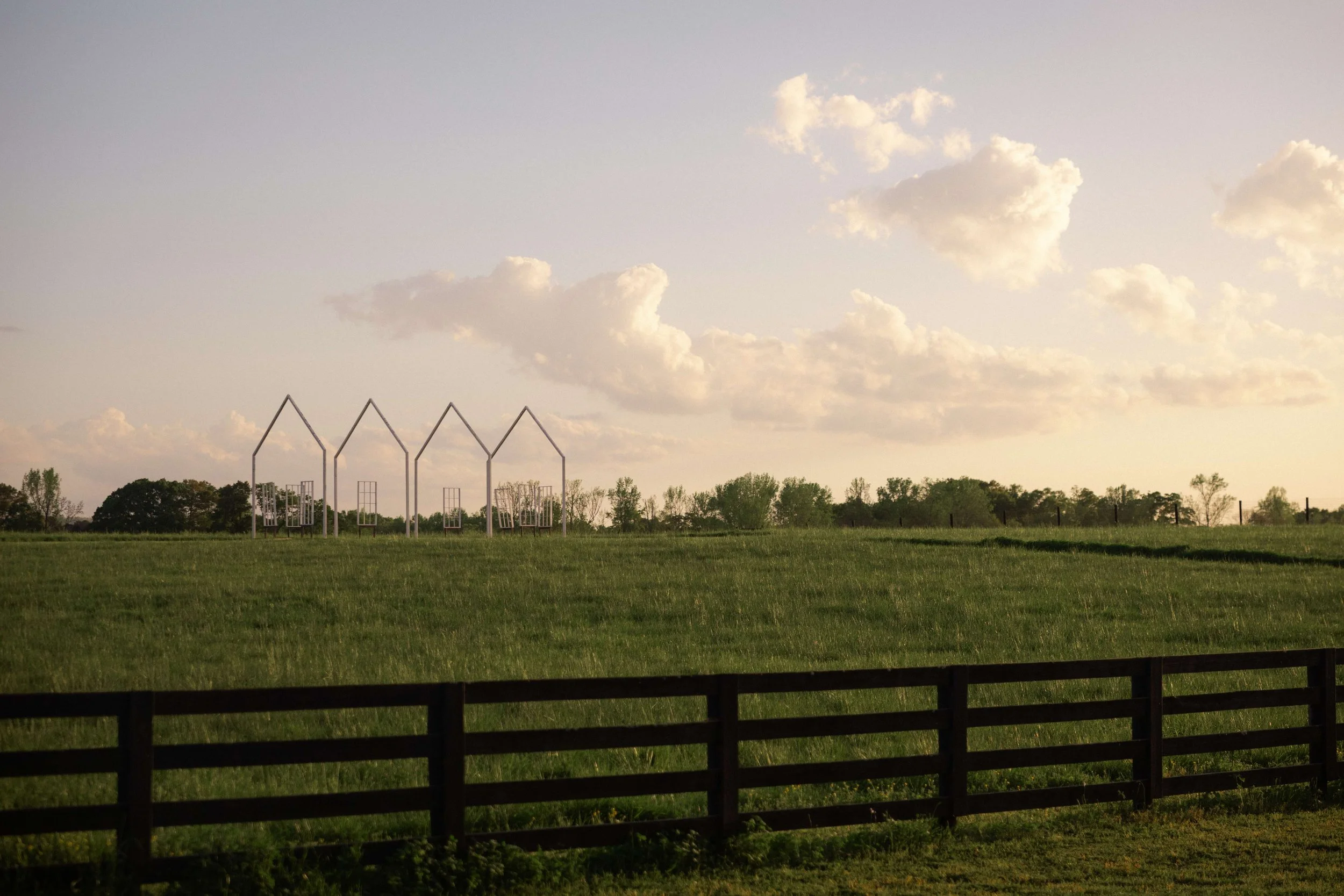 Sunset view of Wild Daisy Farm wedding venue in Molena, Georgia with rustic fence and rolling green pastures