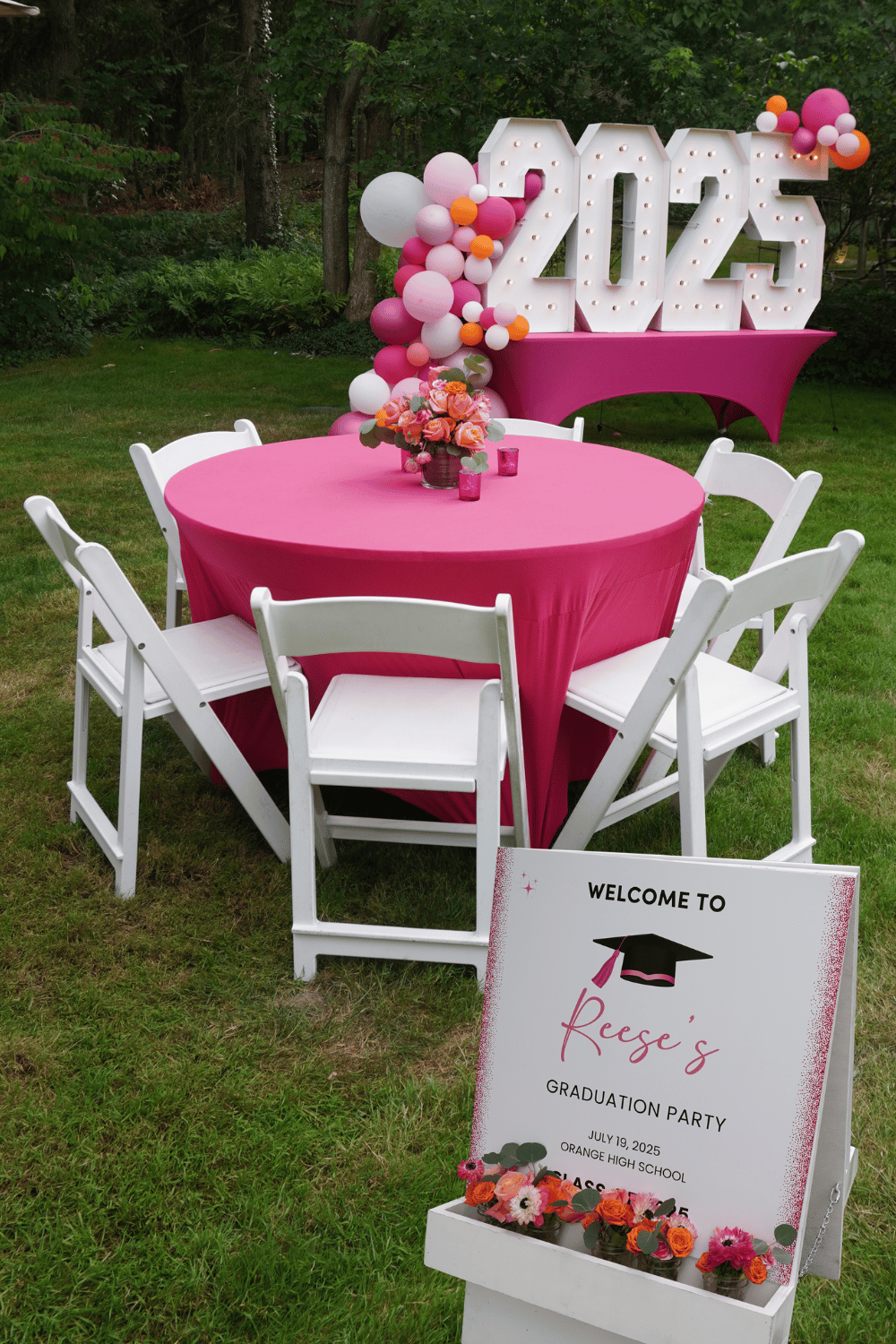 Custom graduation party décor with pink and orange color palette and floral details