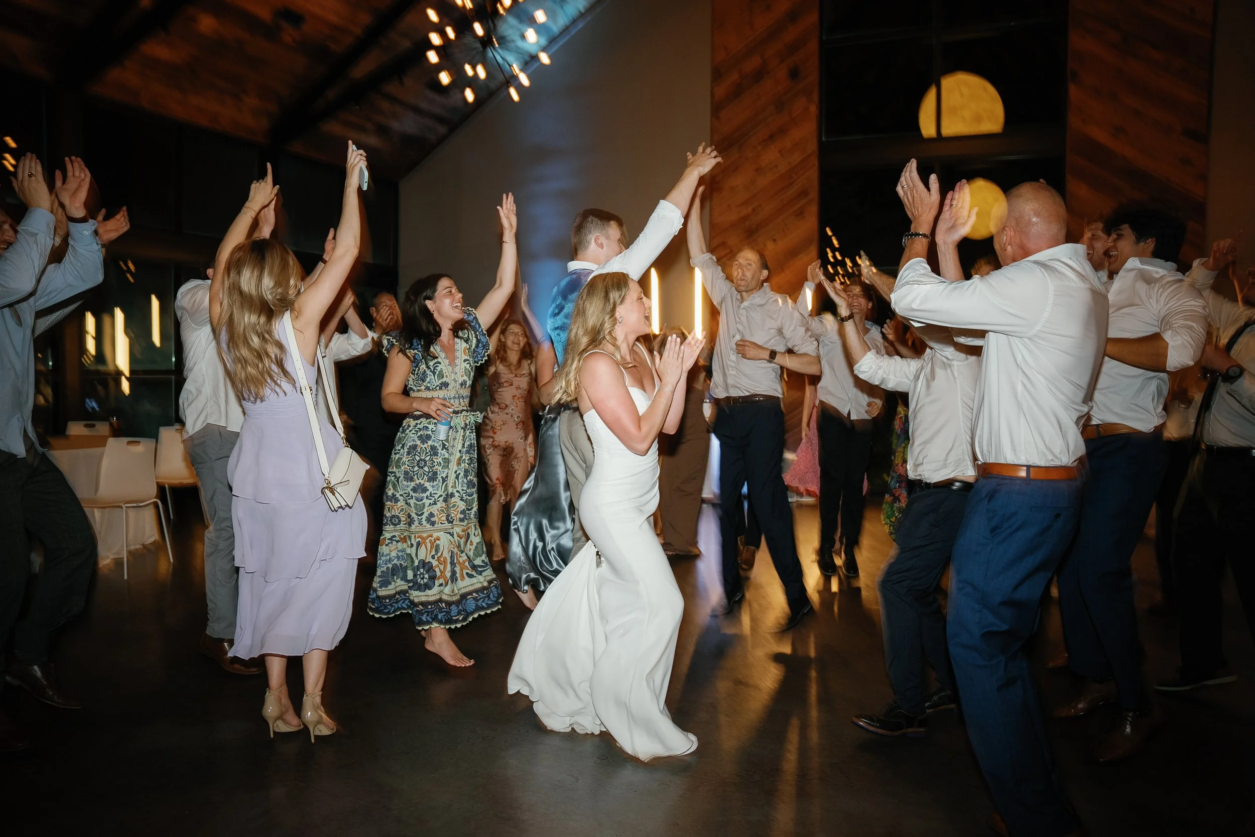 Guests laughing and dancing together during a wedding reception