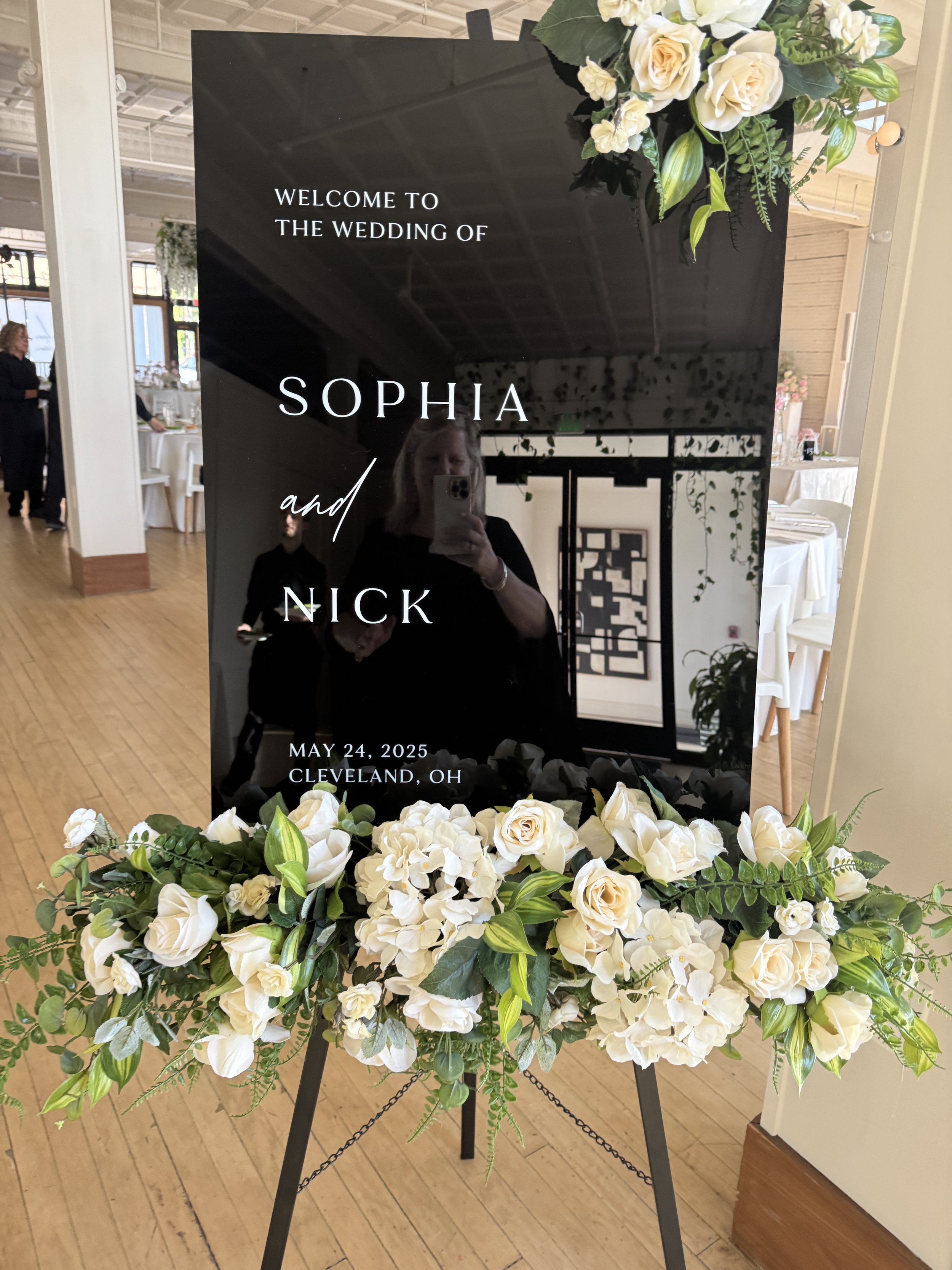 A welcome sign directing guests at a wedding entrance