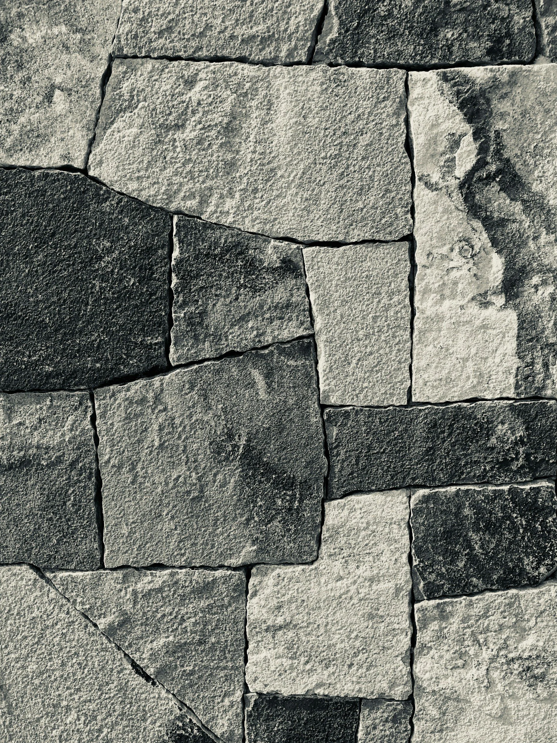 Close-up view of a stone wall made of large, irregularly shaped gray and black stones.