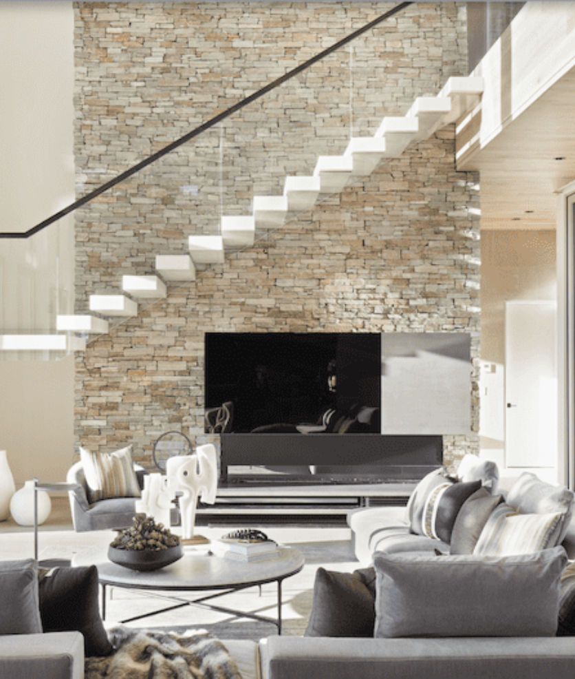 Interior wall with a flat-screen TV mount, a floating shelf, and stone brick design.