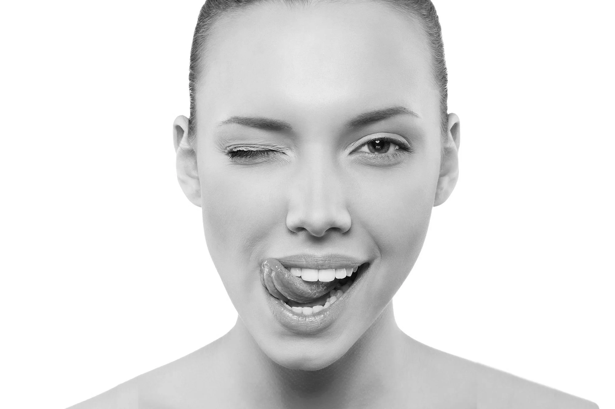 Close-up of a woman winking and sticking her tongue out in a playful manner.