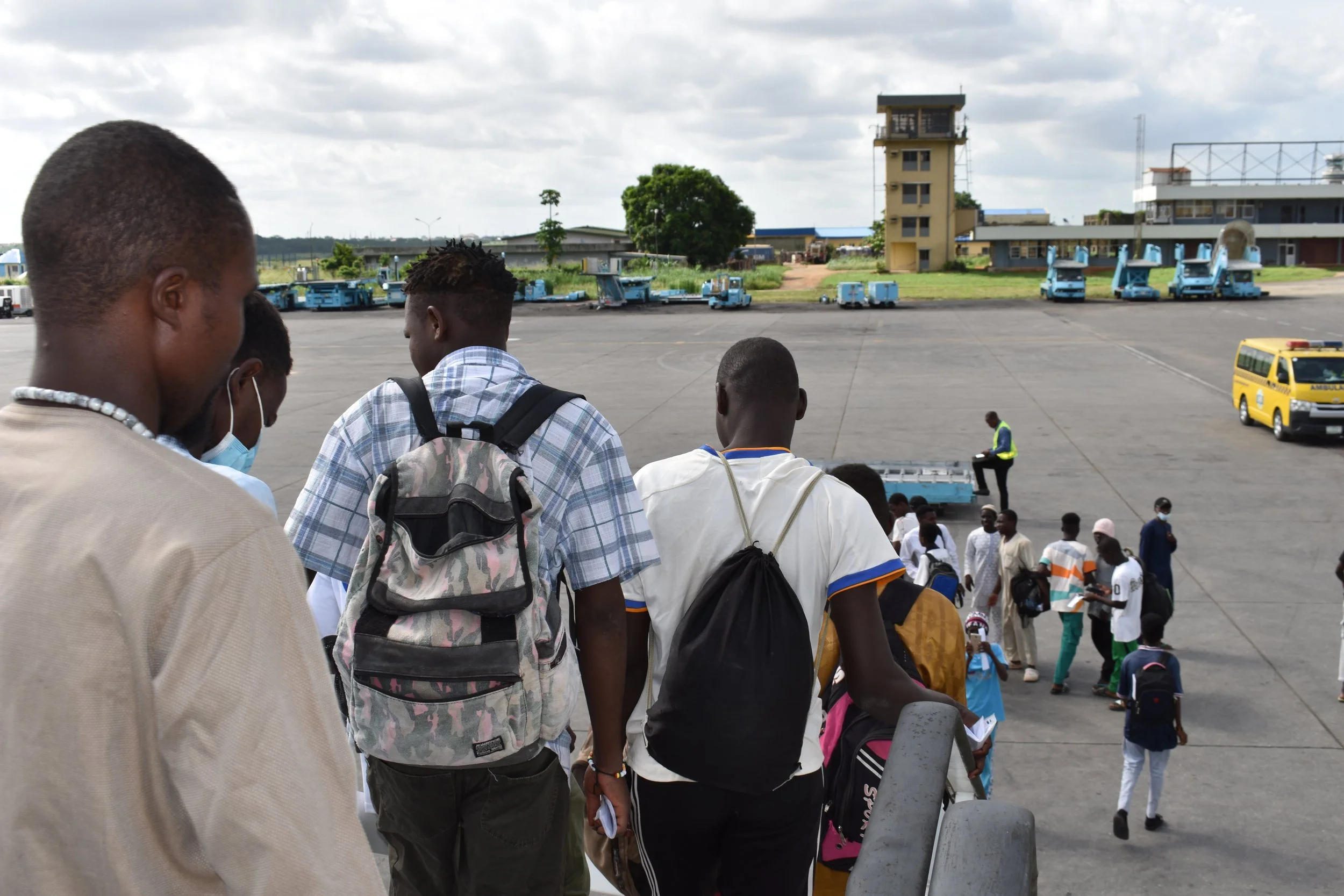 Migrants disembark from the plane.