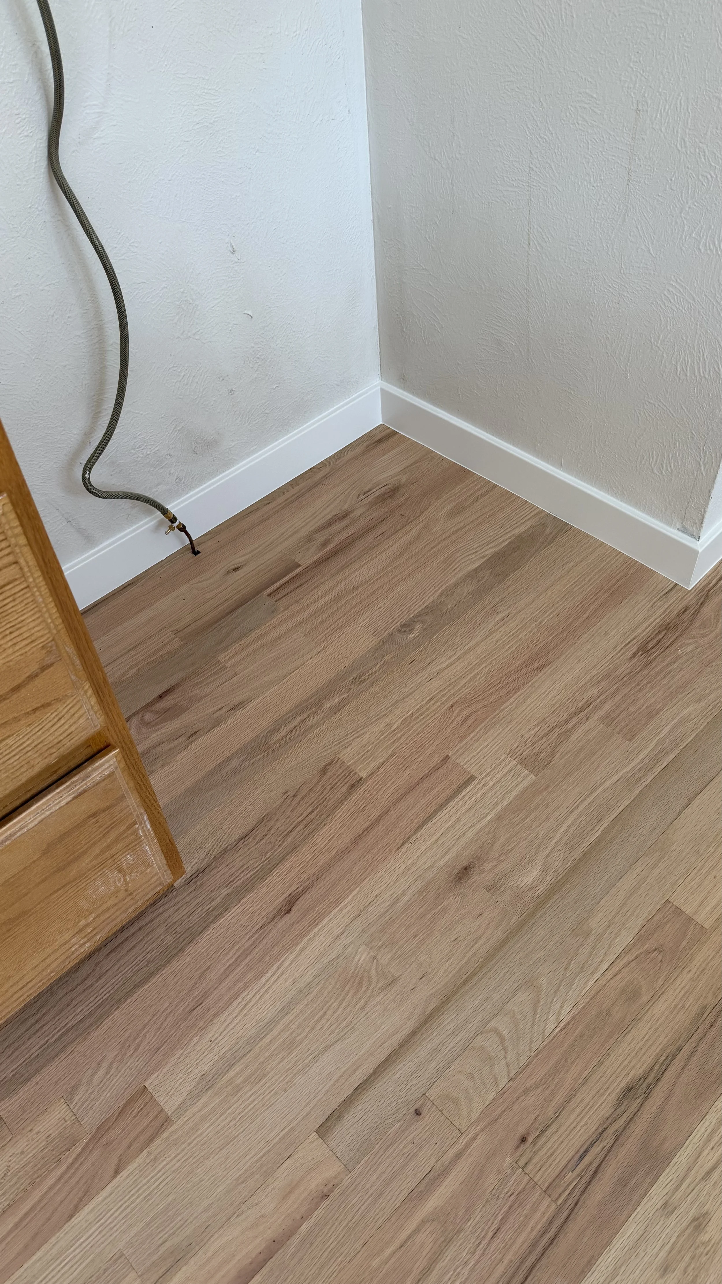 Restored hardwood flooring after water damage repair and refinishing, bringing back a smooth surface and natural wood beauty by Express Hardwood & Flooring.
