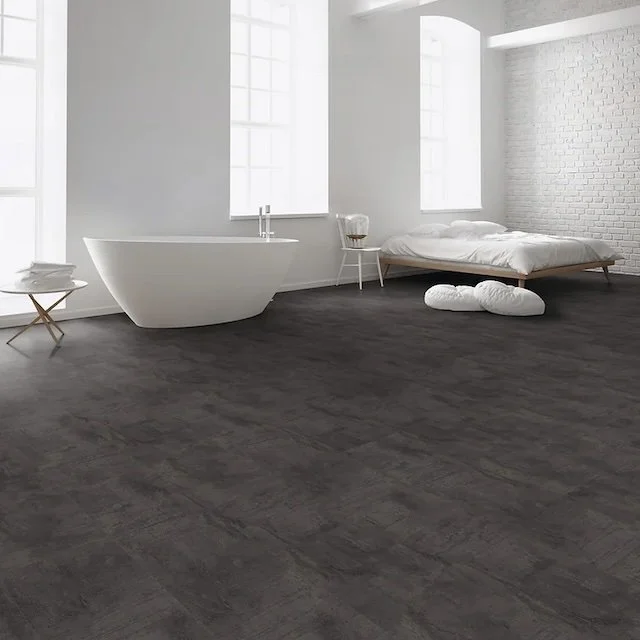 Minimalist bedroom with white walls, large windows, a freestanding bathtub, a bed with white bedding, and dark hardwood floors.
