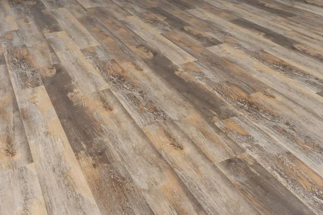 Close-up of a wood-look laminate flooring with a rustic, textured appearance in shades of brown, beige, and gray.