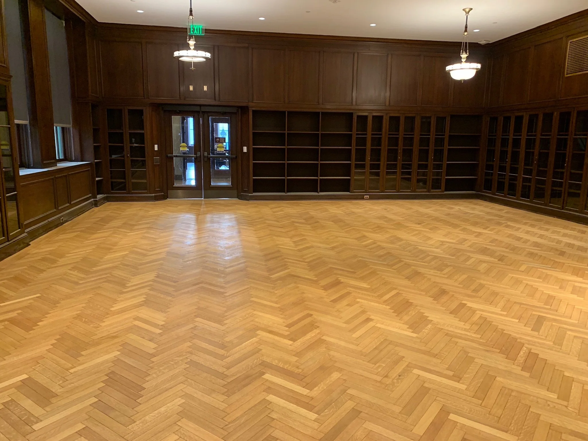 Chevron pattern hardwood floor after sanding and stain application, showcasing a smooth, rich finish and precise craftsmanship by Express Hardwood & Flooring.