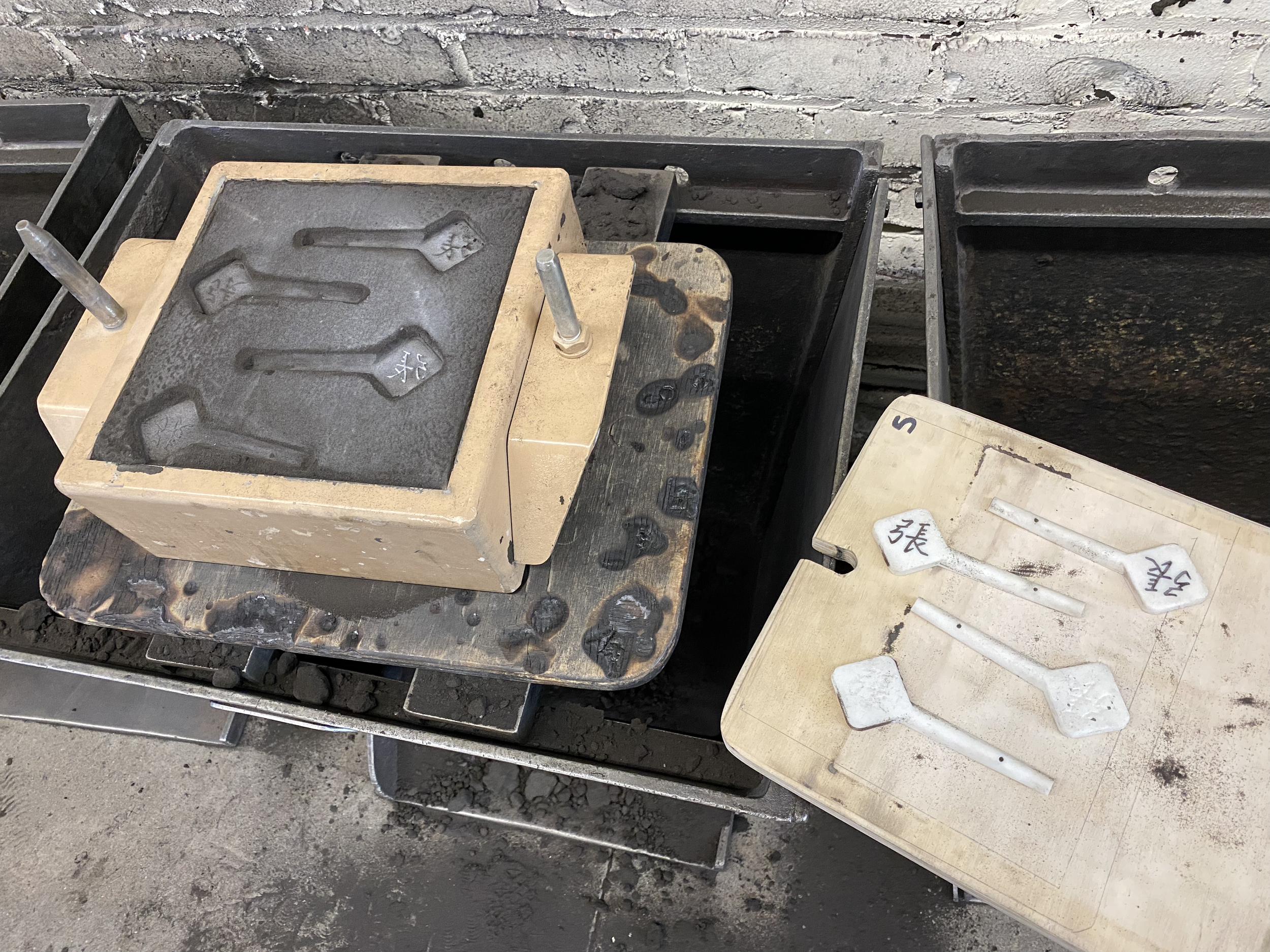 prototyping: rammed up sand casts of same character ( 張 ) with 4 different 3d printed parts with varying depths (0.010" - 0.040")