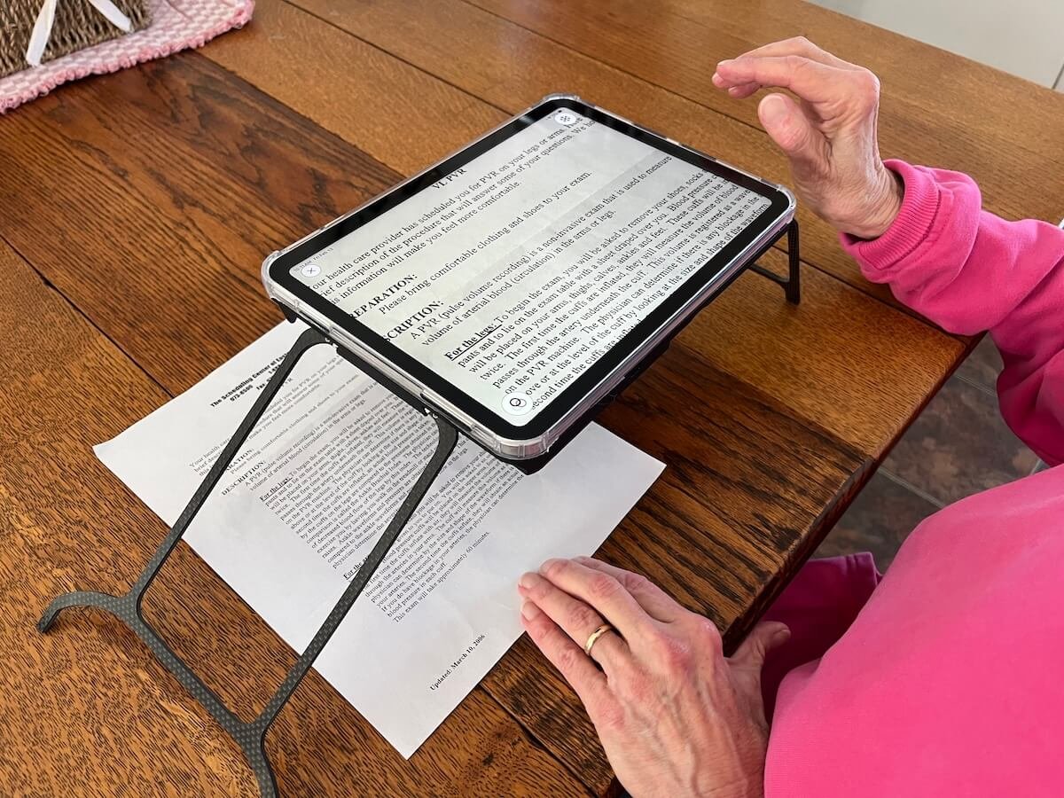 Case for Vision Solaris magnifies an appointment card on a wooden table using black-on-yellow high-contrast mode.