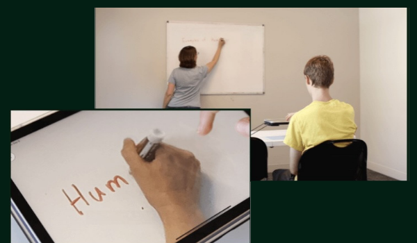 A teacher writes on a whiteboard as a student uses an iPad on a Case for Vision stand showing a magnified view of the text “Human Rights.”
