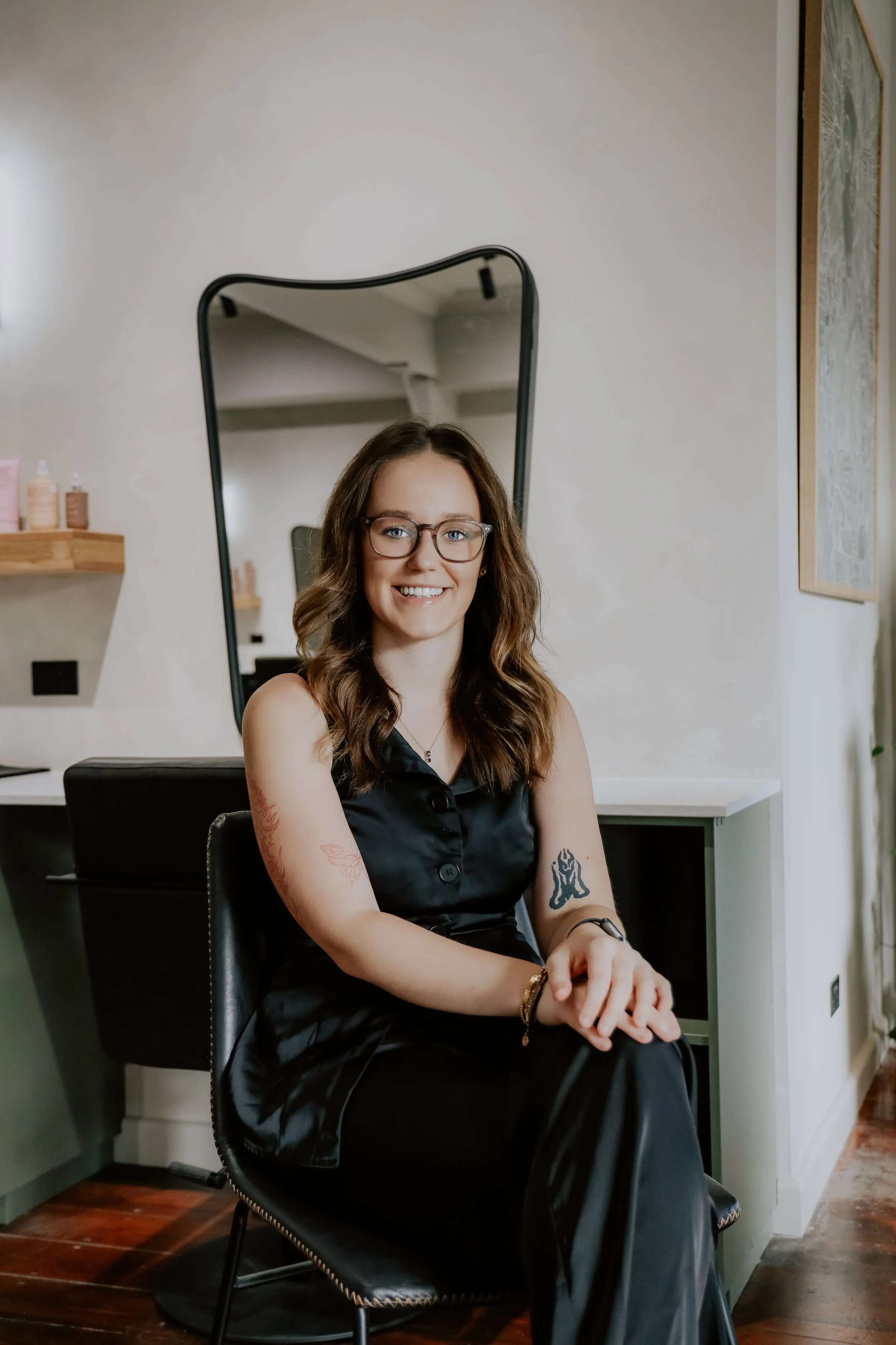Hairdresser applying highlights to a client's hair using foils and a brush in a salon.