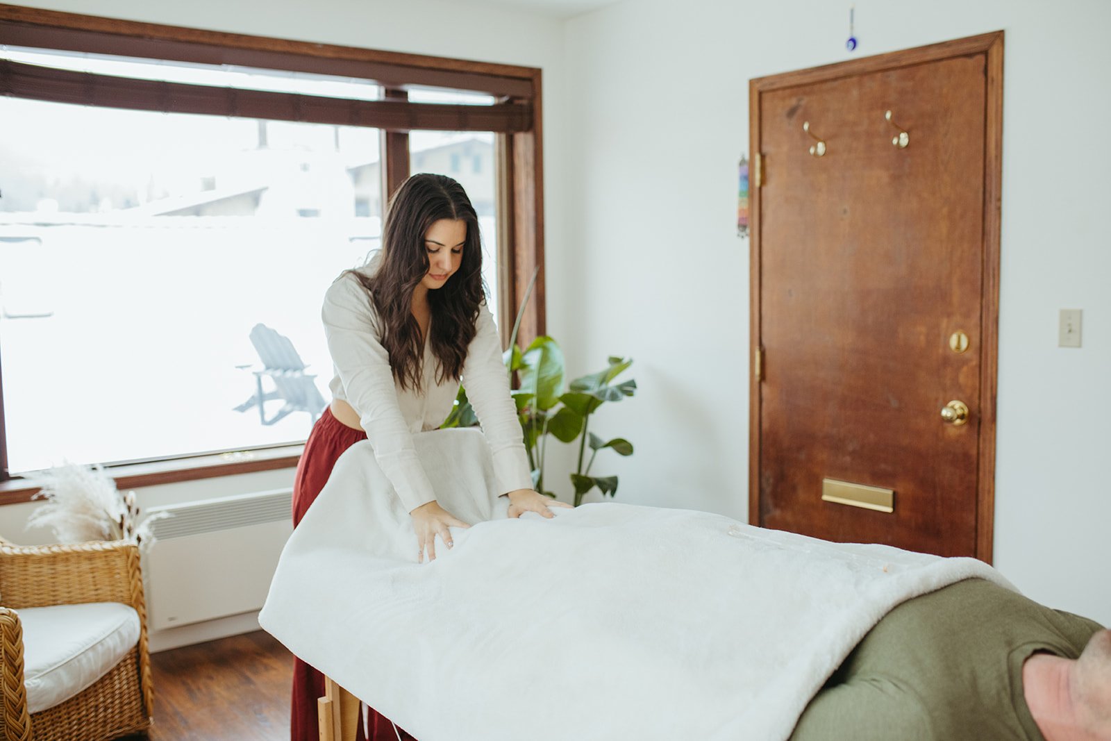 Stephanie Kamille is grounding a client on a massage table by touching their feet
