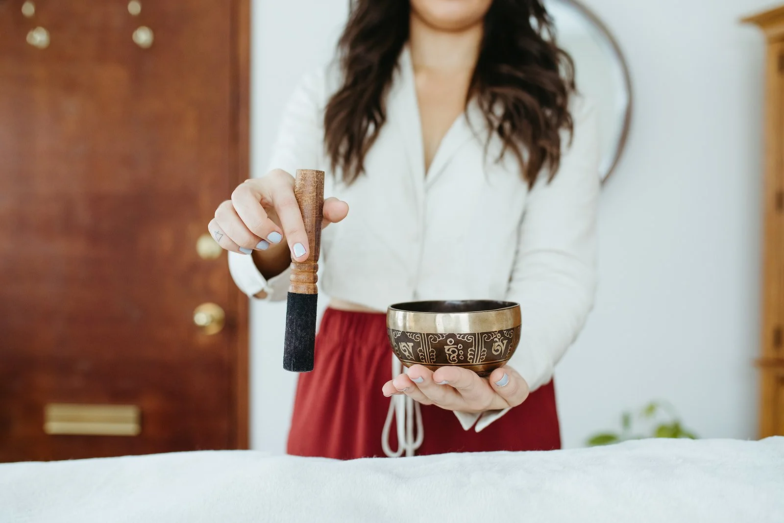 Stephanie Kamille is holding a singing bowl above a reiki client