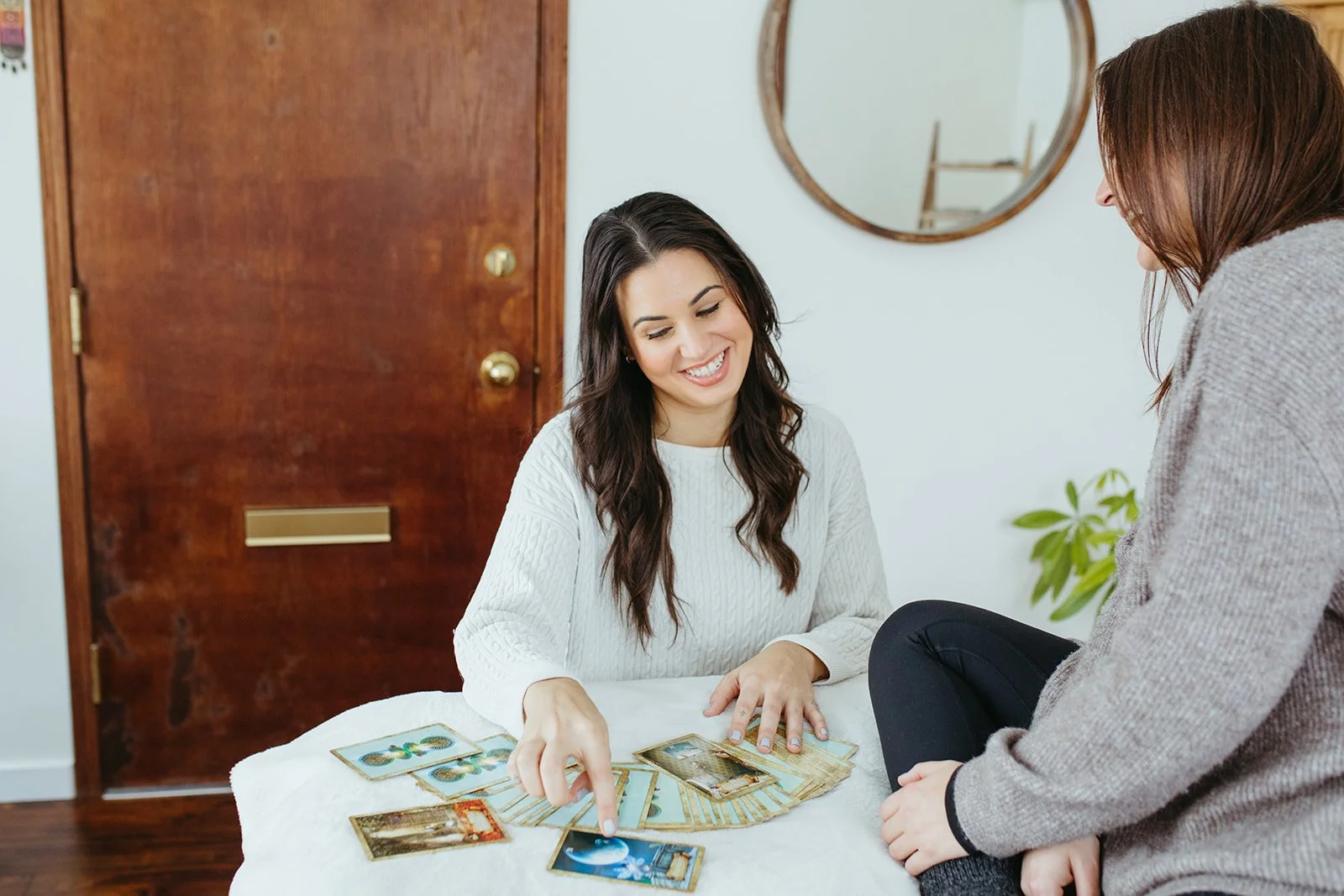Stephanie Kamille with oracle cards fanned out on a table with a female client