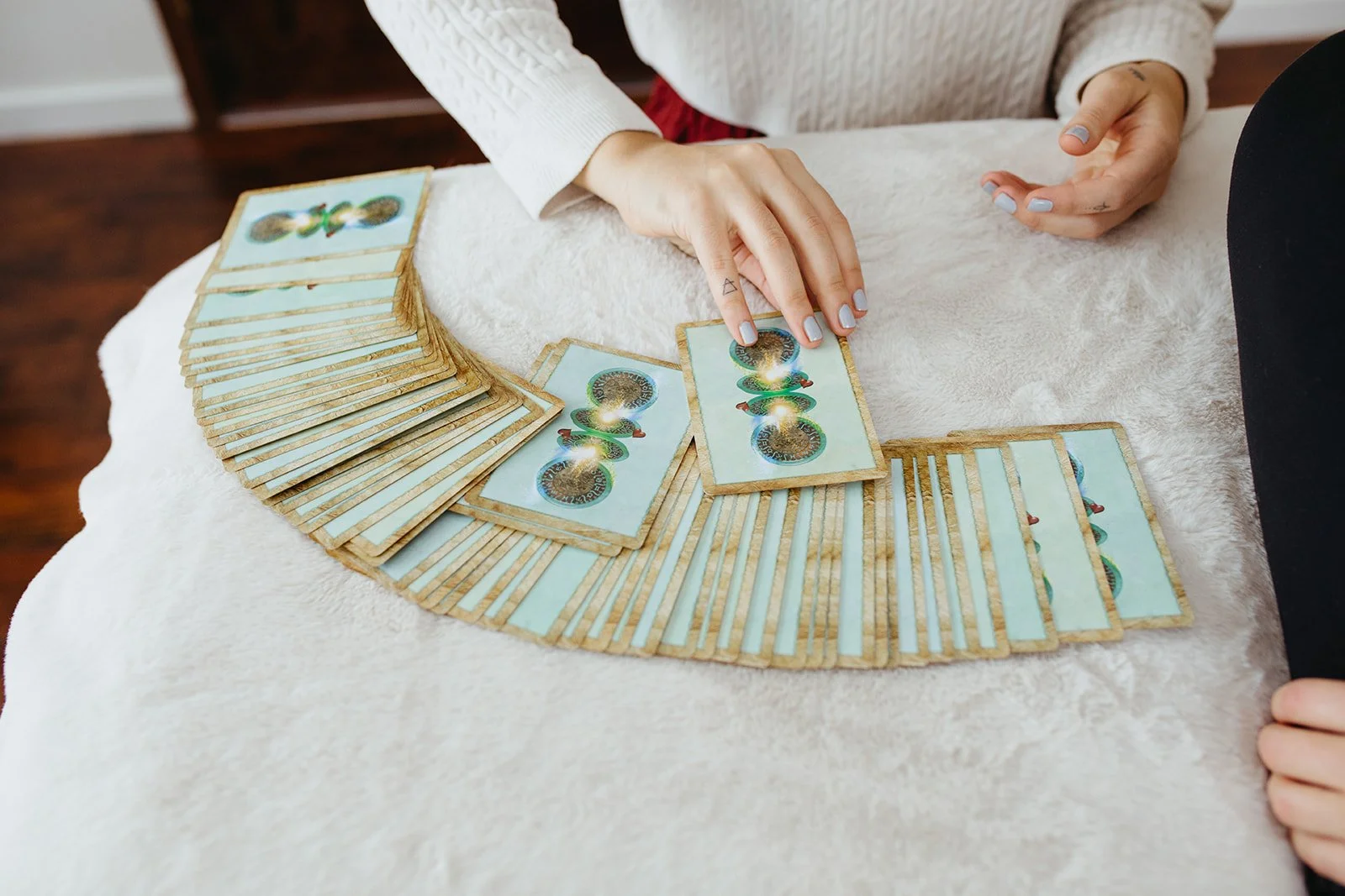 oracle cards fanned out with Stephanie Kamille picking one out